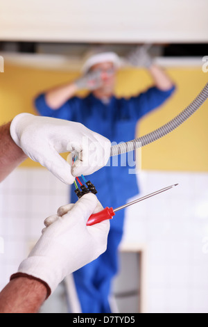 Zwei Elektriker Reparatur Deckenbeleuchtung Stockfoto