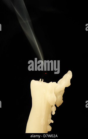 Erloschene Kerze vor einem schwarzen Hintergrund. Stockfoto
