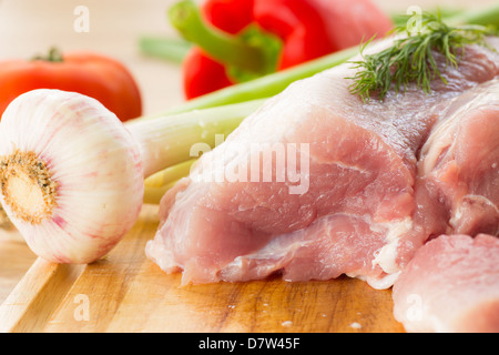 Stück rohes Schweinefleisch auf einem Holzbrett Stockfoto