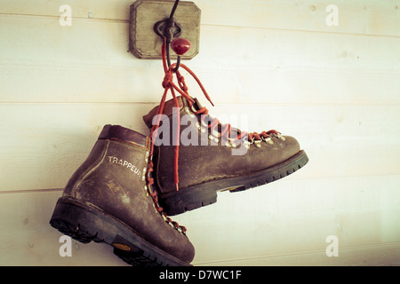 Lederschuhe hängen an einer Holzwand Stockfoto