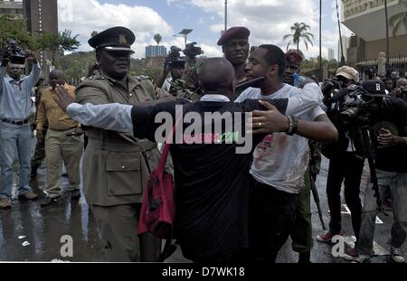 Nairobi, Kenia. 14. Mai 2013. Einem anderen Aktivisten versucht, Boniface Mwangi (blutverschmierte weißes T-shirt), schützen vor der Polizei. Mwangi war einer der Organisatoren des Protestes '' besetzen Parlament ''. '' Wir vergossen haben das Blut von Schweinen zu zeigen, dass die Abgeordneten gierig wie die Schweine,'' sagte Mwangi. Er und andere Organisatoren der Veranstaltung wurden verhaftet. (Bild Kredit: Kredit: Ric Francis/ZUMAPRESS.com/Alamy Live-Nachrichten) Stockfoto