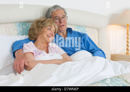 Älteres Ehepaar im Bett liegend Stockfoto