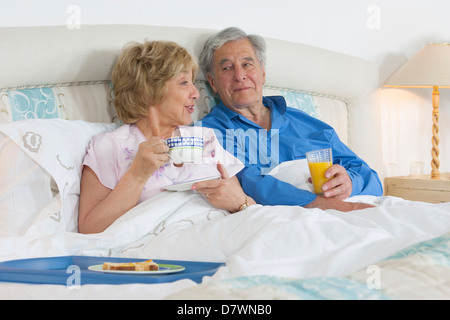 Älteres Ehepaar im Bett frühstücken Stockfoto