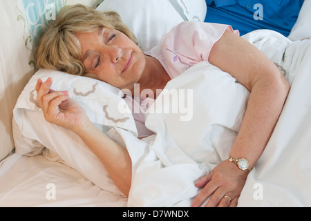 Ältere Frau in ihrem Bett schlafen Stockfoto
