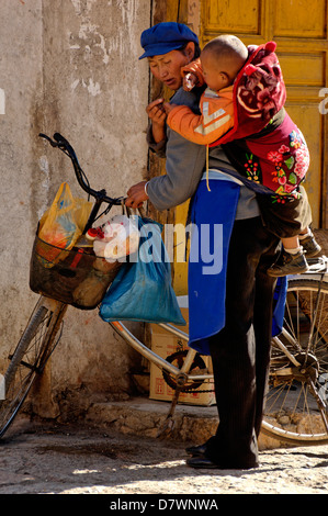Frau mit Baby, Baisha Dorf in der Nähe von Lijiang, Yunnan, China Stockfoto