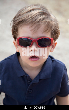 Niedliche kaukasischen zwei Jahre alt Blondschopf mit Sonnenbrille in einem sonnigen Sommernachmittag. Stockfoto