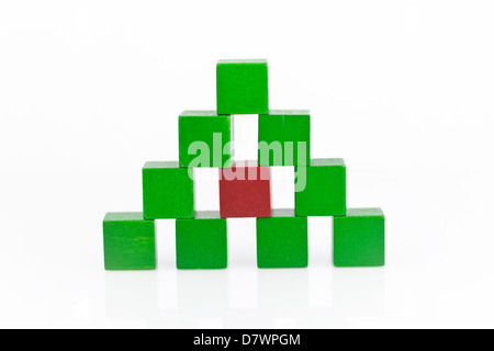 Pyramide gemacht aus grünen Holzblöcken mit einem "roten" in der Mitte Stockfoto