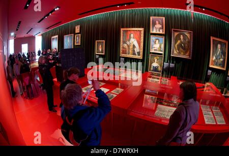 Leute betrachten historische Porträts während der Eröffnungsrundgang des Palastmuseums im neu restaurierten Schloss Herrenhausen in Hannover, Deutschland, 14. Mai 2013. Hunderte von Objekten sind auf dem Display, einen Einblick in die Geschichte der Kurfürsten und Könige von Hannover und der Barockzeit von den berühmten Gärten geben. Foto: HOLGER HOLLEMANN Stockfoto