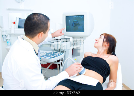 Ein Arzt zeigt dem Patienten auf dem Monitor das Ultraschallbild. Stockfoto