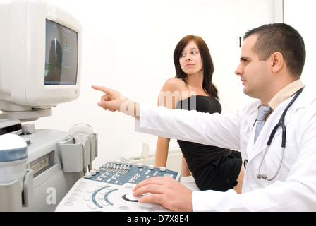 Ein Arzt zeigt dem Patienten auf dem Monitor das Ultraschallbild. Stockfoto