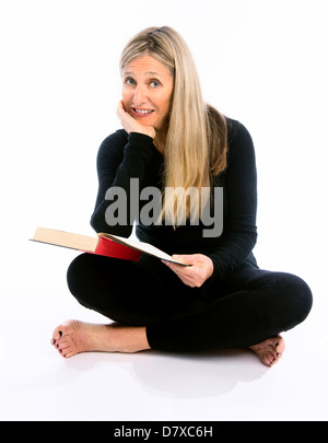 Ältere Frau lächelt bei Buch Stockfoto