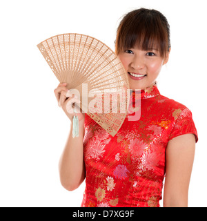 Schöne Asiatin mit chinesischen traditionellen Kleid Cheongsam hält eine chinesische Fan isoliert auf weißem Hintergrund Stockfoto