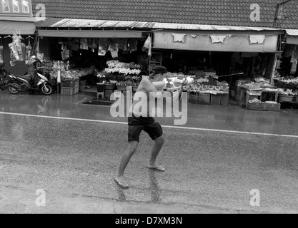 PHUKET, THAILAND, 13. April 2013: Ein ausländischer Tourist erwirbt ein Ziel für seine Wasserpistole während Songkran 2013 in Phuket. Stockfoto