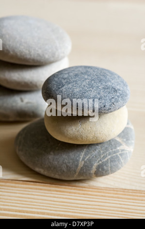 Sechs Spa Zen Steinen gestapelt auf einem hellen Hintergrund Holz Stockfoto