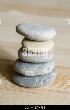 Fünf Spa Zen Steinen gestapelt auf einem hellen Hintergrund Holz Stockfoto