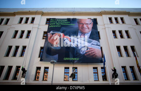 Greenpeace-Aktivisten hängen einen Banner zeigt ein Foto der Bundesumweltminister Peter Altmaier vor Polizisten an das Bundesministerium für Umwelt in Berlin, Deutschland, 15. Mai 2013. Das Banner liest "Herr Altmaier, Klimaschutz anstatt Gas Guzzlers zu unterstützen!". Foto: KAY NIETFELD Stockfoto