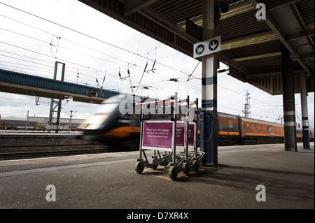 Ein Hochgeschwindigkeitszug durch einen Bahnhof, UK. Stockfoto