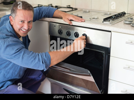 Elektriker arbeiten am Ofen in der Küche Stockfoto