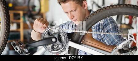 Mann arbeitet auf dem Fahrrad im shop Stockfoto