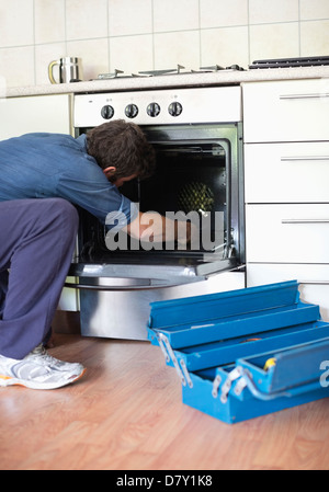 Elektriker arbeiten am Ofen in der Küche Stockfoto