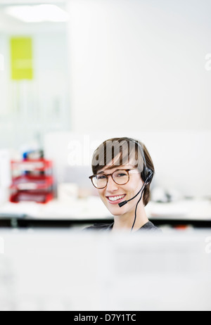 Geschäftsfrau tragen Kopfhörer im Büro Stockfoto