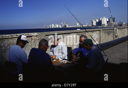 Männer spielen Backgammon auch genannt Shesh besh an der Valparaiso Stadtmauer Promenade entlang der Mittelmeerküste des alten Jaffa und Tel Aviv Skyline im Hintergrund Israel Stockfoto