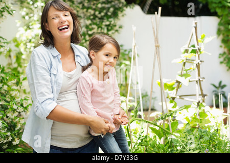 Schwangere Mutter und Tochter zusammen im Garten Stockfoto