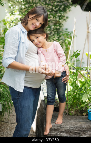 Schwangere Mutter und Tochter umarmt im freien Stockfoto