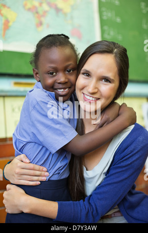 Lehrer und Schüler in der Klasse umarmt Stockfoto