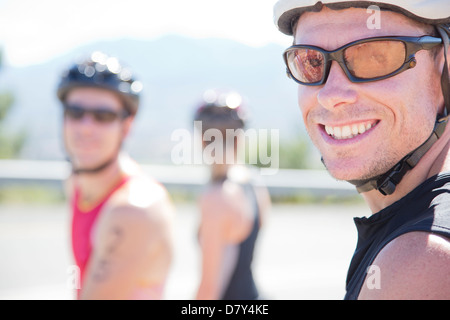 Radfahrer, die lächelnd auf Landstraße Stockfoto