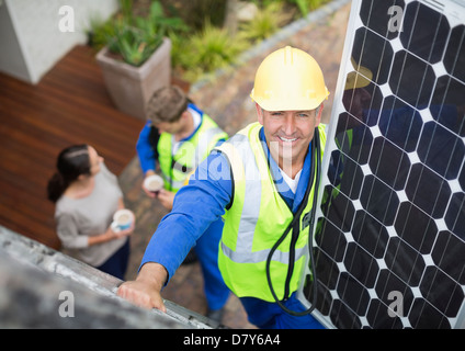 Arbeiter, die Installation von Solar-Panel auf Dach Stockfoto