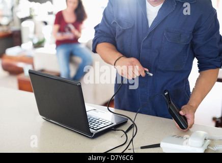 Elektriker mit Laptop im Haus Stockfoto