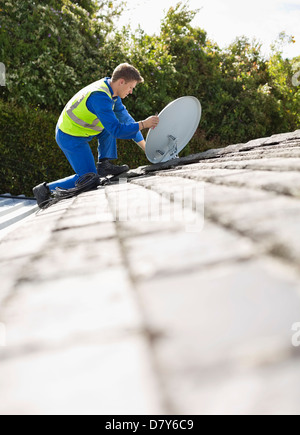 Arbeiter, die Installation von Sat-Schüssel auf Dach Stockfoto