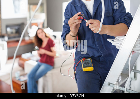 Elektriker arbeiten im Wohnzimmer Stockfoto