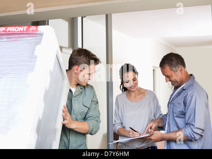 Frau, die Unterzeichnung für die Lieferung an die Haustür Stockfoto