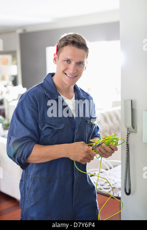 Elektriker arbeiten am Telefon im Haus Stockfoto