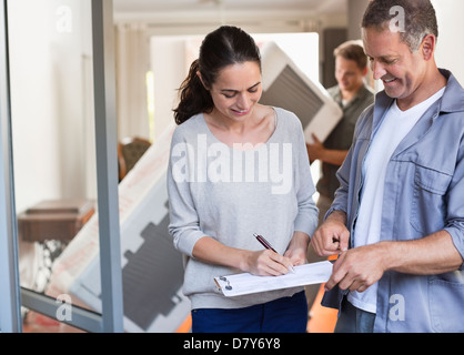 Frau, die Unterzeichnung für Paket Stockfoto