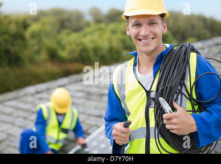 Arbeiter, die lächelnd auf Dach Stockfoto