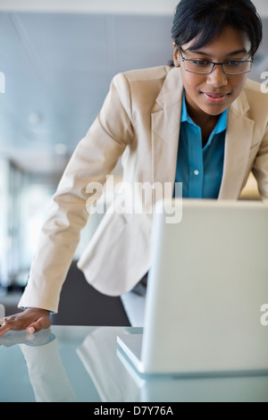 Geschäftsfrau, die Arbeiten am Laptop an der Rezeption Stockfoto
