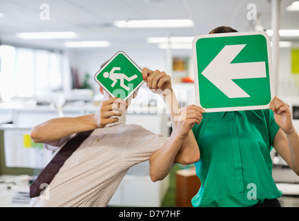 Geschäftsleute, die mit Schildern im Büro Stockfoto