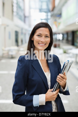 Geschäftsfrau, die Ordner im Büro tragen Stockfoto