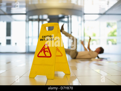 Unternehmer, die ein Ausrutschen auf nassen Büroetage Stockfoto