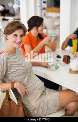 Schwangere Frau, die Tasse Kaffee mit Freunden Stockfoto