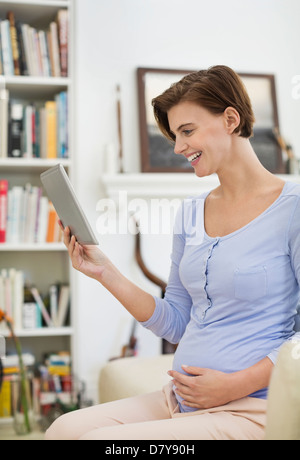 Schwangere Frau mit Tablet-PC Stockfoto