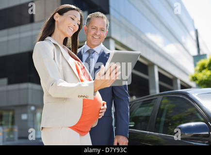 Schwanger Geschäftsfrau und Kollegen mit Tablet-PC Stockfoto