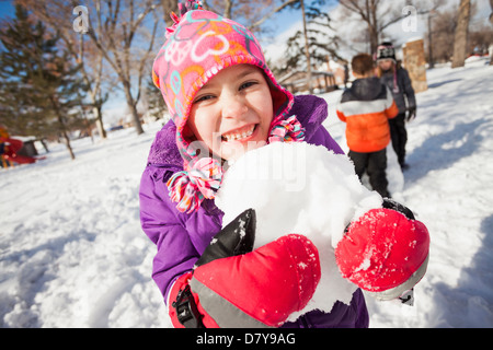 Kaukasische Mädchen Holding Schneeball im freien Stockfoto