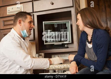 Kaukasische Zahnarzt und Frau im Gespräch im Büro Stockfoto