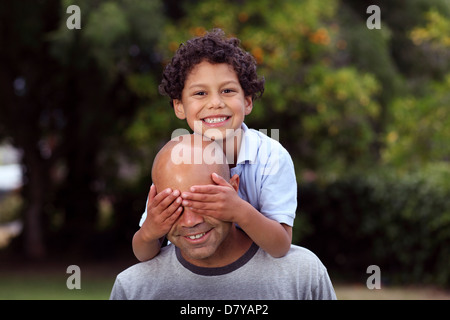 Mischlinge-Vater und Sohn im Garten hinter dem Haus spielen Stockfoto