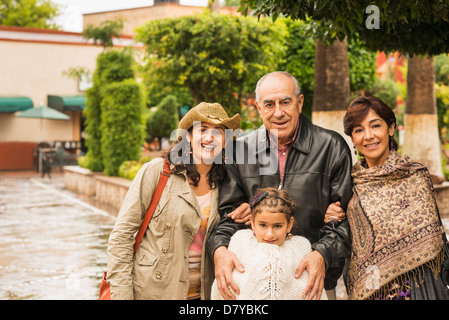 Familie lächelnd zusammen im freien Stockfoto