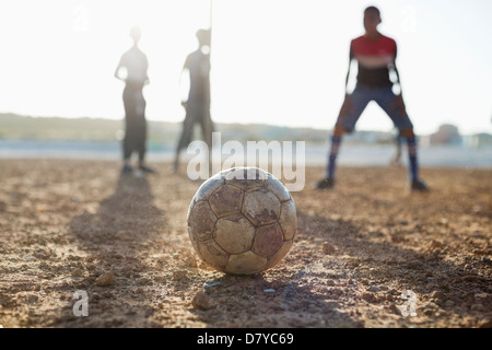 Jungs spielen Fußball zusammen in Schmutz Feld Stockfoto